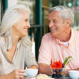 An elderly couple enjoying a cup of coffee together