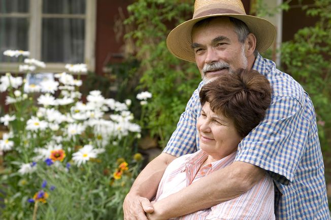 An elderly couple embarrassing in a garden